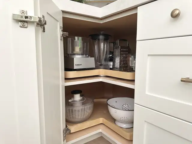 Custom corner cabinet with two-tier wood lazy Susan shelves holding small appliances, built in the APlus Anaheim cabinet shop