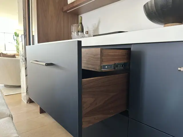Close view of a navy custom cabinet with walnut interior drawer built in the APlus Anaheim cabinet shop