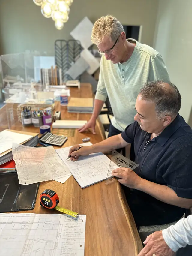 Kitchen plans being sketched at the APlus design table, with tile and finish samples behind