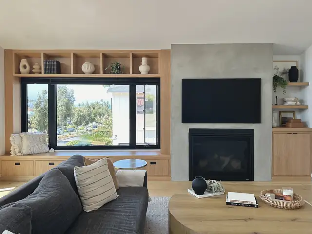 Family room remodel with custom oak built-in shelving, window seat and plaster fireplace surround in an Orange County home