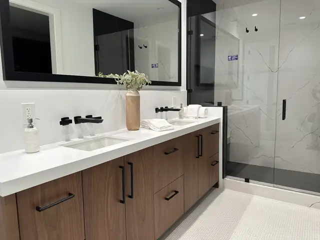 Dana Point bathroom remodel with walnut vanity, white quartz counter, black fixtures and frameless glass shower