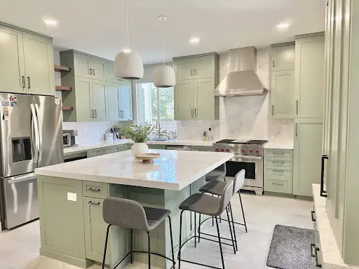 Tustin kitchen remodel with greige custom cabinets, island seating, white pendant lights and stainless range hood